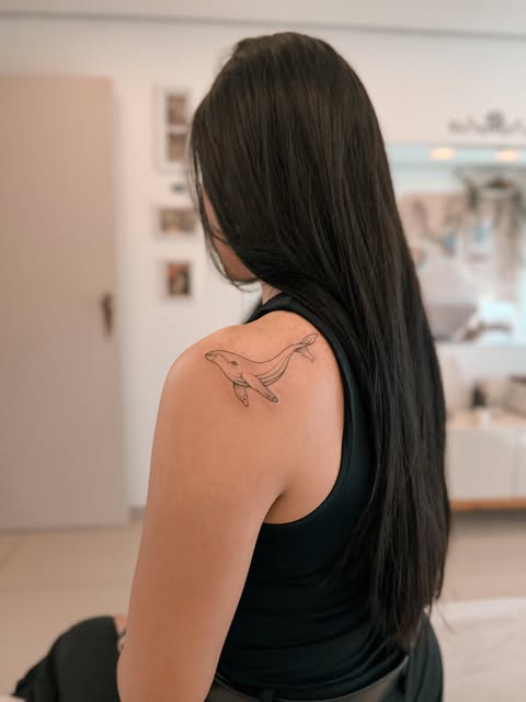 Baleia-jubarte minimalista em traço fino no ombro